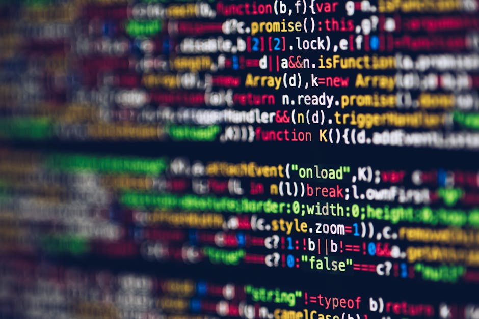 Close-up image of a computer screen displaying a dense layer of colorful programming code, including HTML, JavaScript, and CSS snippets. The code features various tags, functions, variables, and synta